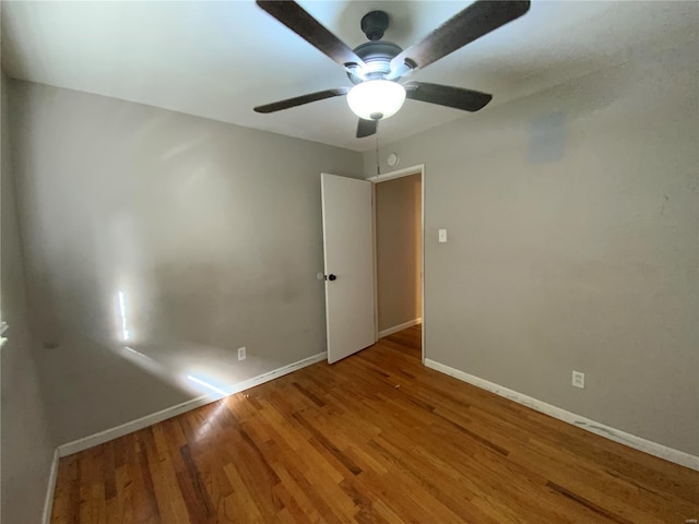 empty room with hardwood / wood-style flooring and ceiling fan