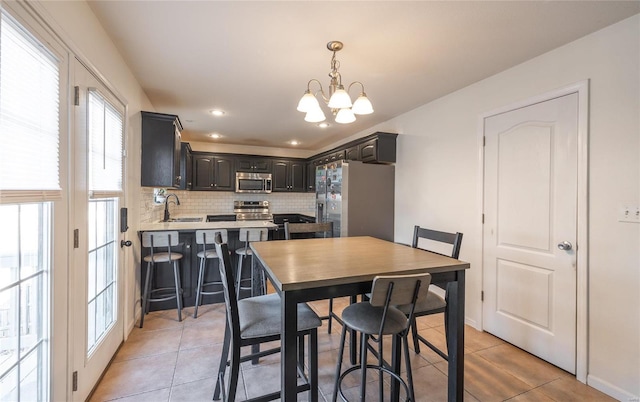 tiled dining area featuring an inviting chandelier and sink