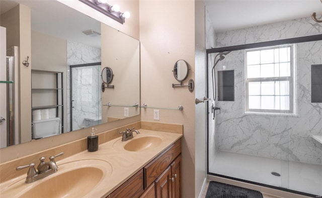 bathroom featuring a shower with door and vanity