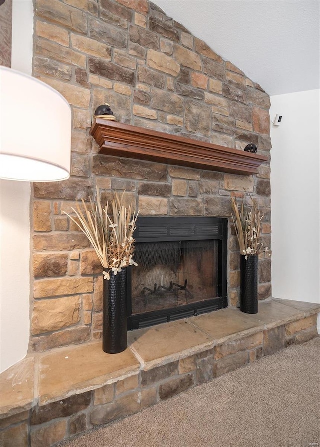 interior details featuring carpet and a stone fireplace