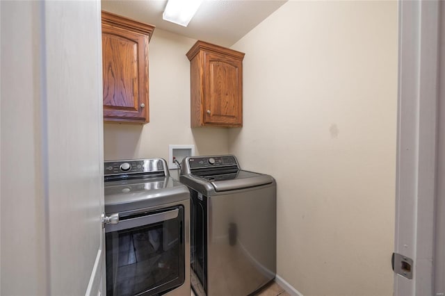 washroom featuring washing machine and dryer and cabinets