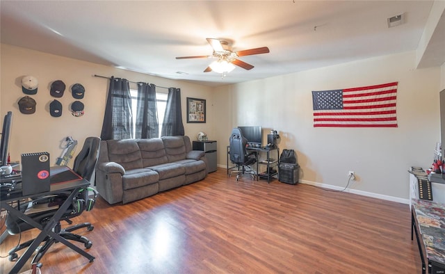 living room featuring ceiling fan and dark hardwood / wood-style floors