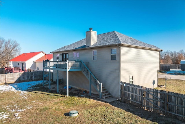 rear view of property featuring a deck and a lawn