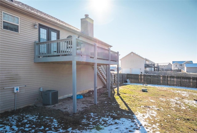 back of property featuring a yard, a wooden deck, and cooling unit