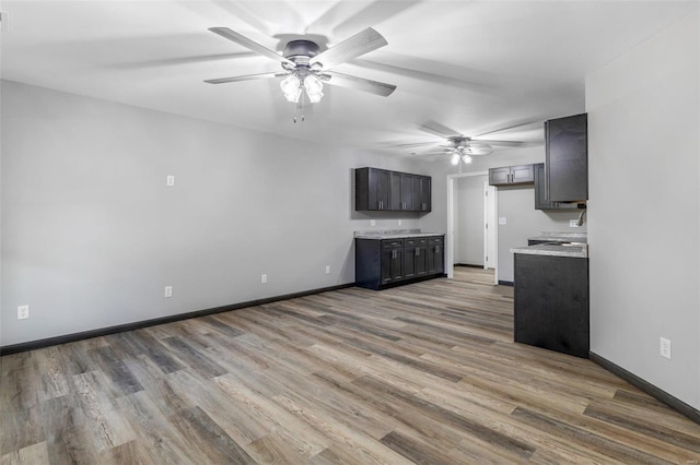 unfurnished living room featuring ceiling fan and light wood-type flooring