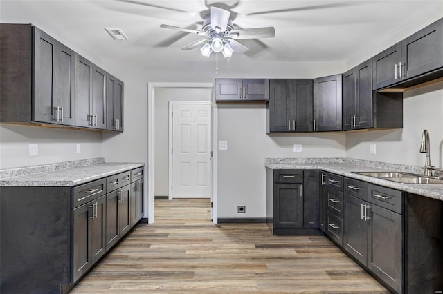 kitchen with ceiling fan, sink, and light hardwood / wood-style floors