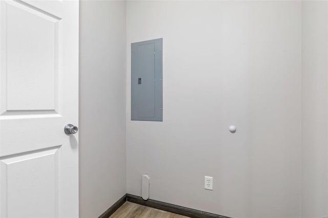 unfurnished room featuring electric panel and light hardwood / wood-style floors