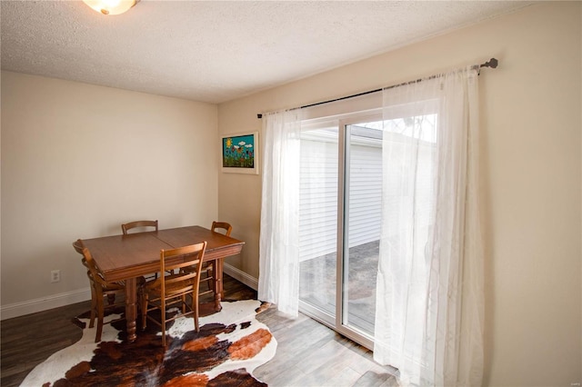 dining space featuring hardwood / wood-style flooring and a textured ceiling