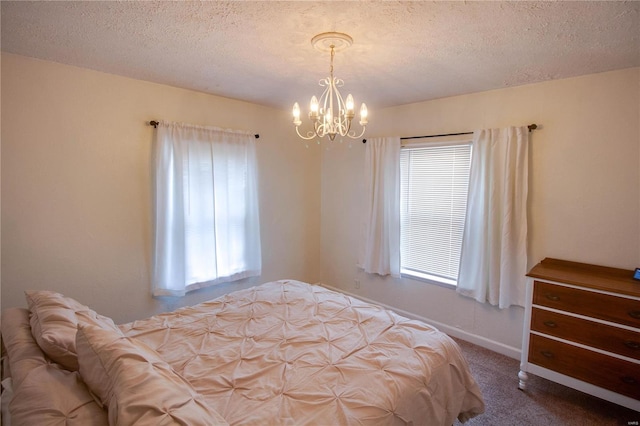 carpeted bedroom featuring a textured ceiling and an inviting chandelier