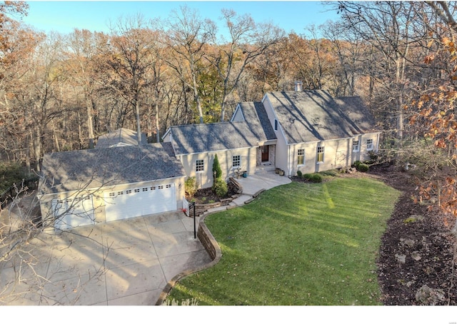 view of front facade featuring concrete driveway, an attached garage, and a front lawn