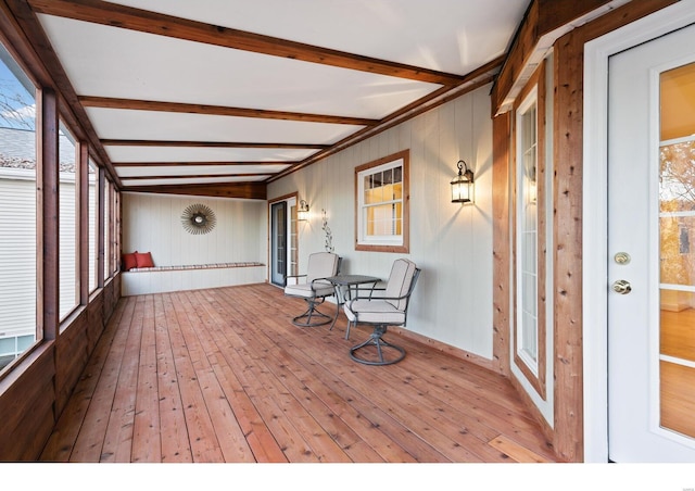 unfurnished sunroom featuring beam ceiling