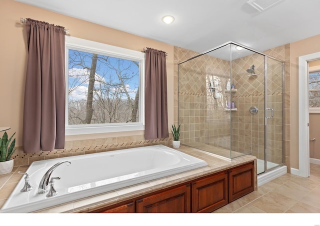 bathroom featuring tile patterned flooring, a shower stall, and a bath