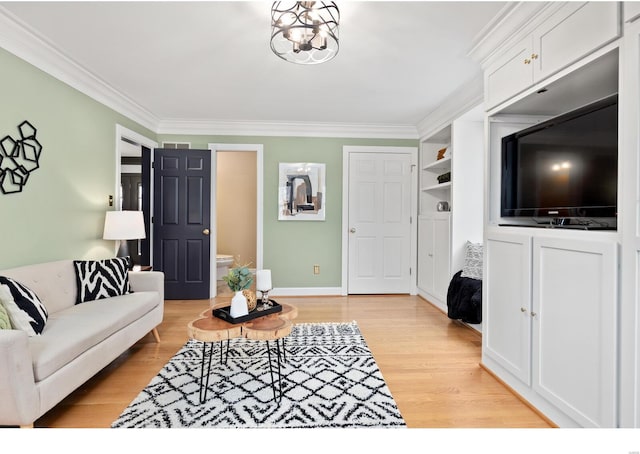 living area with baseboards, light wood finished floors, an inviting chandelier, and crown molding