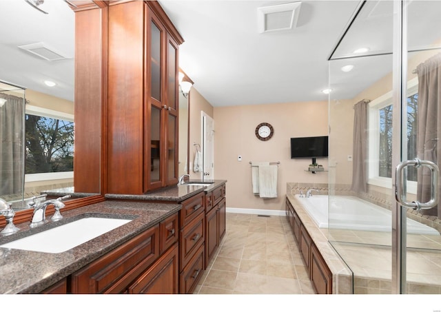 full bathroom featuring plenty of natural light, visible vents, a sink, and double vanity