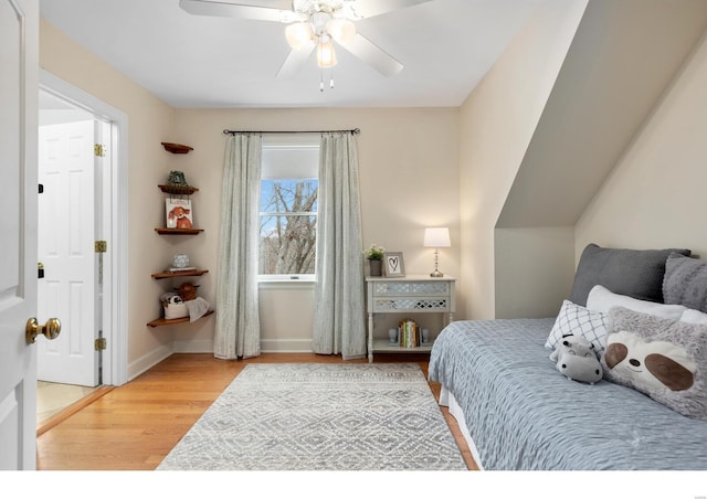 bedroom featuring ceiling fan, baseboards, and wood finished floors