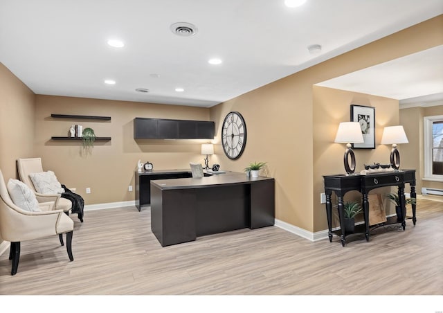 office area with light wood-style floors, visible vents, and baseboards