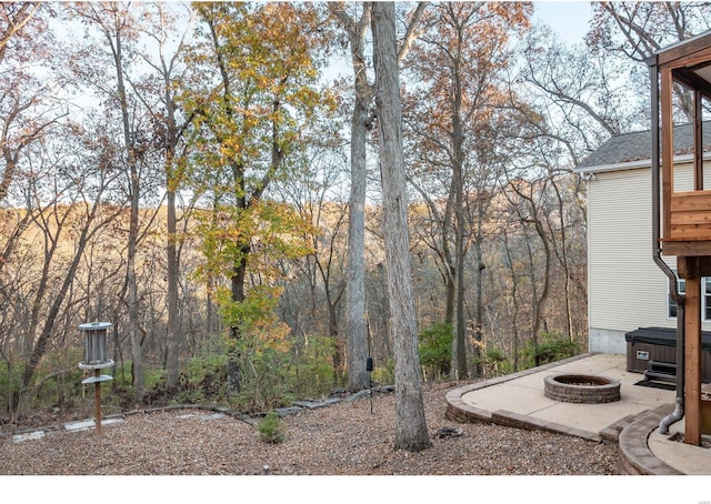 view of yard featuring a hot tub, an outdoor fire pit, and a patio