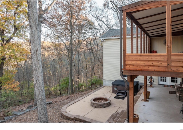 view of patio featuring a hot tub and an outdoor fire pit