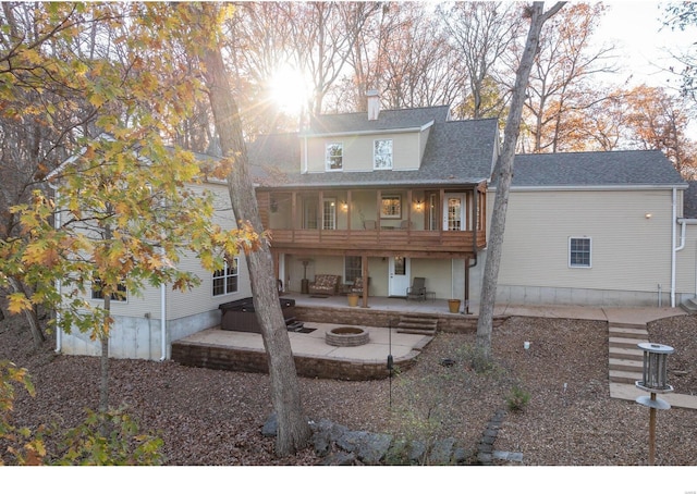 rear view of property featuring a chimney, a patio area, a fire pit, and roof with shingles