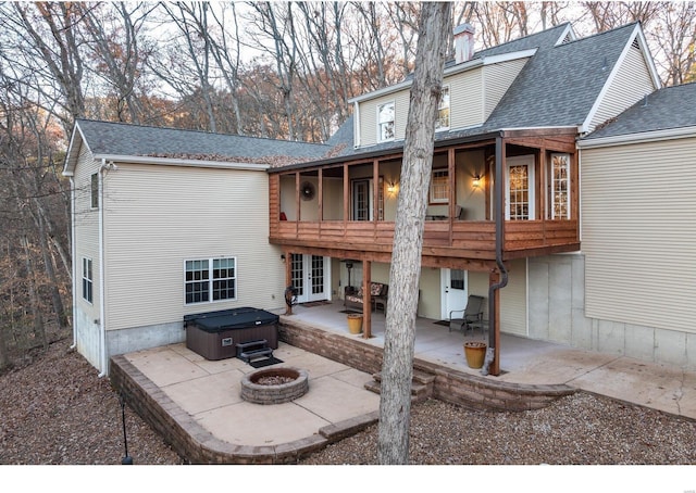 rear view of property featuring french doors, a patio, a shingled roof, a hot tub, and an outdoor fire pit