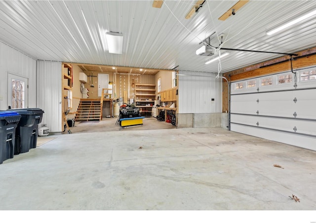 garage with a workshop area, metal wall, and a garage door opener