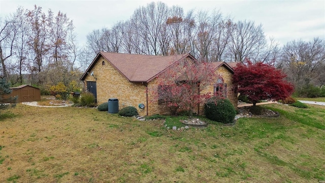 view of side of home featuring a yard, central AC, and a storage unit