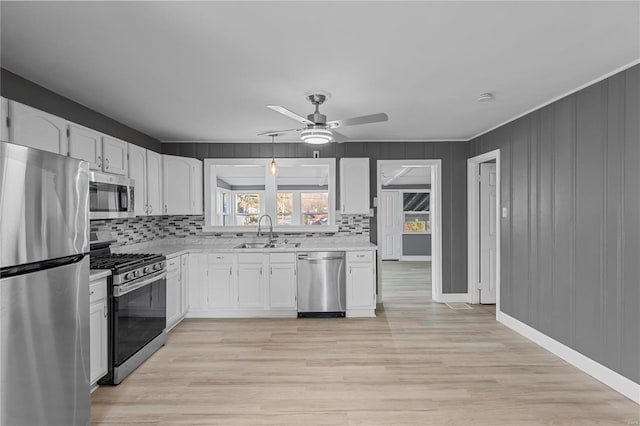 kitchen with decorative backsplash, sink, white cabinets, and stainless steel appliances