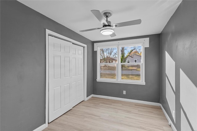 unfurnished bedroom featuring ceiling fan, a closet, and light hardwood / wood-style flooring