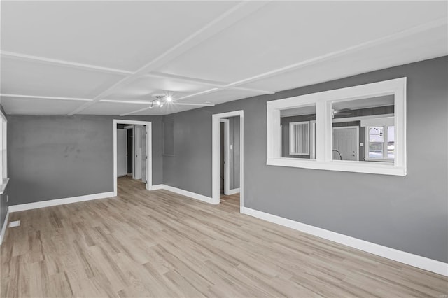 spare room with light hardwood / wood-style floors and coffered ceiling