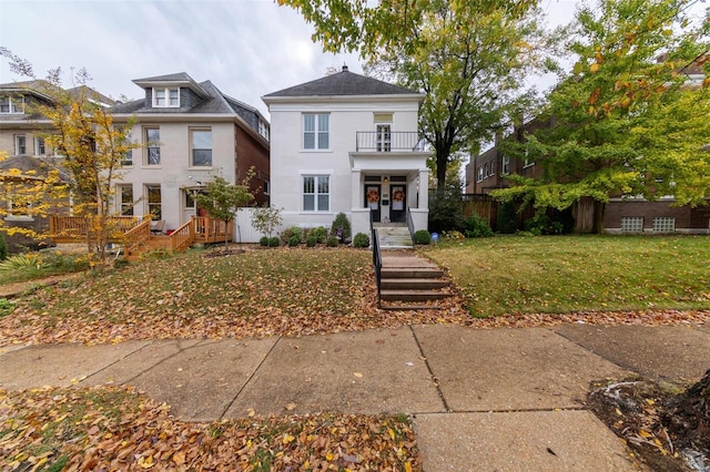 view of front of home featuring a balcony and a front lawn