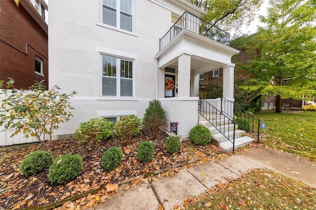 view of exterior entry featuring a balcony