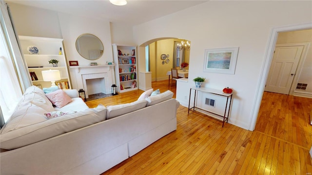 living room featuring light hardwood / wood-style flooring and an inviting chandelier