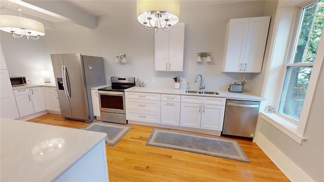 kitchen featuring appliances with stainless steel finishes, decorative light fixtures, and a notable chandelier