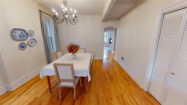 dining space featuring a notable chandelier and light hardwood / wood-style floors