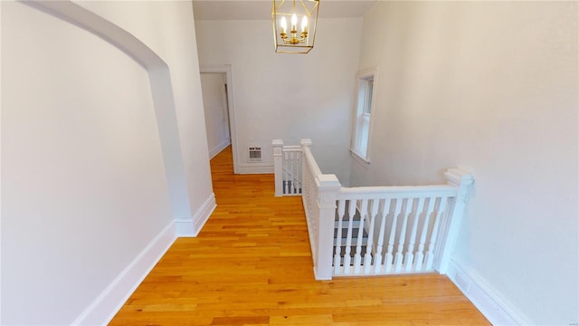 hall with a notable chandelier and light wood-type flooring