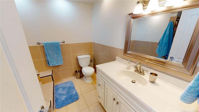 bathroom with tile patterned flooring, vanity, tile walls, and toilet