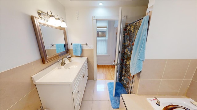 bathroom featuring tile patterned floors, vanity, and tile walls