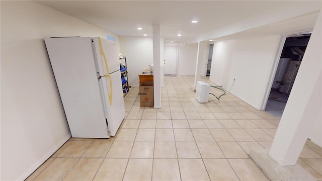 interior space with water heater, light tile patterned floors, and white refrigerator