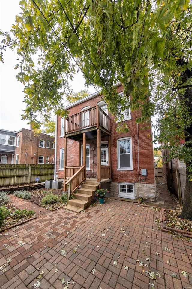 rear view of property with a balcony and central AC unit