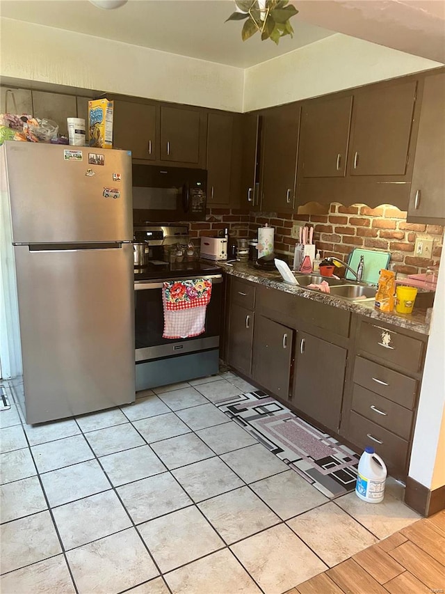 kitchen with dark brown cabinets, decorative backsplash, sink, and appliances with stainless steel finishes