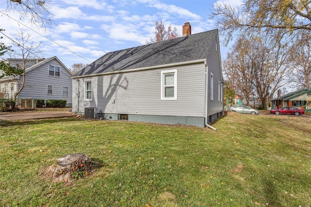 back of property with a yard and central air condition unit