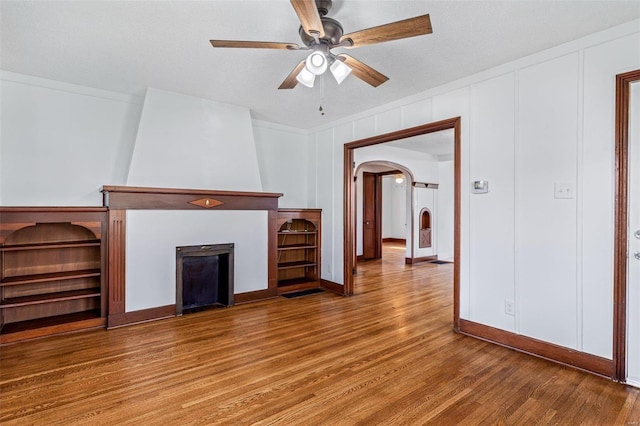 unfurnished living room featuring ceiling fan, a textured ceiling, and hardwood / wood-style flooring