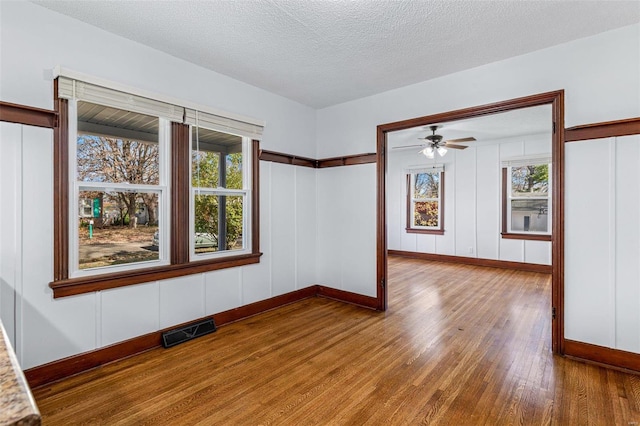 spare room featuring ceiling fan, wood-type flooring, and a textured ceiling