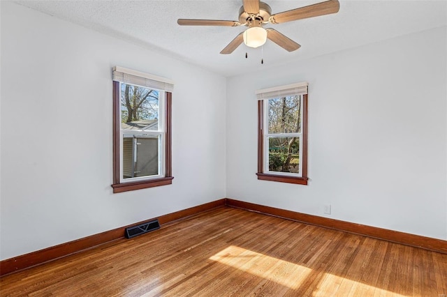 spare room featuring wood-type flooring, a textured ceiling, and ceiling fan