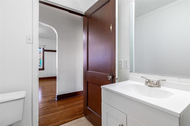 bathroom with wood-type flooring, vanity, and toilet