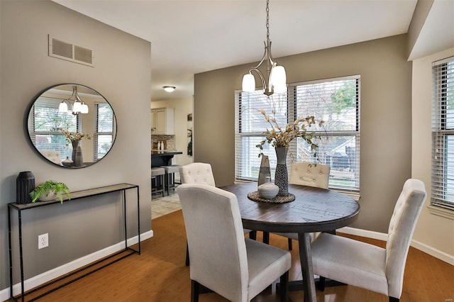 dining area featuring hardwood / wood-style flooring and a notable chandelier