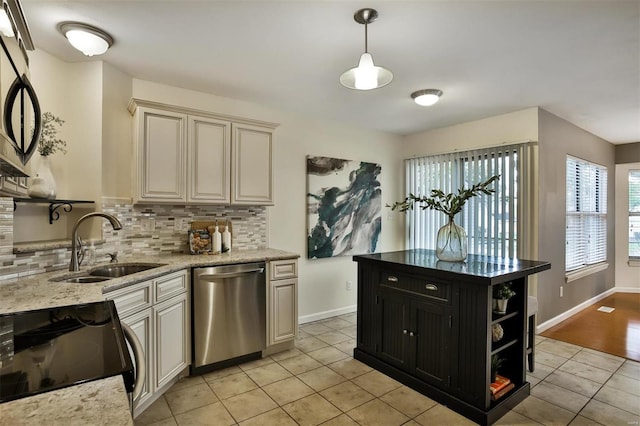 kitchen featuring light stone countertops, sink, hanging light fixtures, tasteful backsplash, and appliances with stainless steel finishes