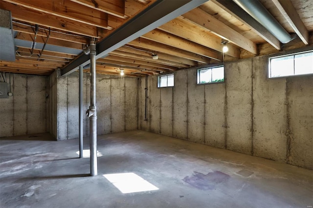 basement with electric panel and a wealth of natural light