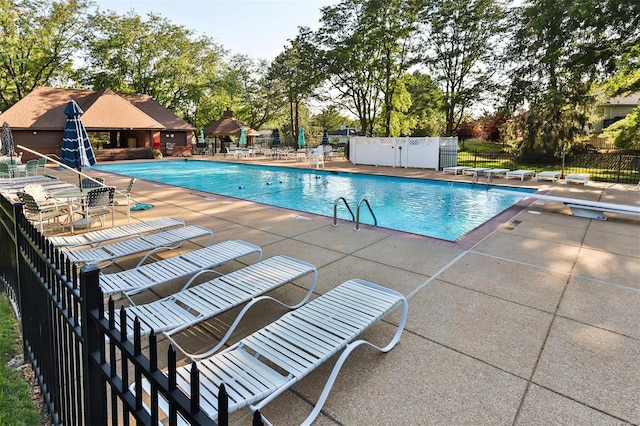 view of pool featuring a diving board and a patio