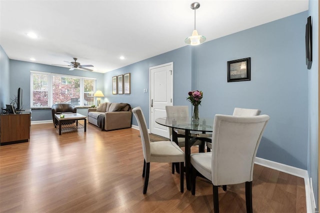 dining area featuring wood-type flooring and ceiling fan